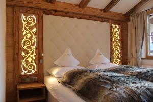 a bedroom with a bed with a gold head board at Chaletresort Lech in Holzgau