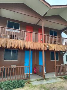 a house with a balcony with a deck at Tiongman Scubadive & Lodge in Tioman Island