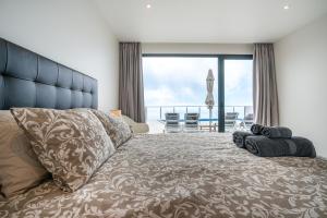 a bedroom with a large bed with a view of the ocean at Casa Bella Vista - Calheta in Arco da Calheta