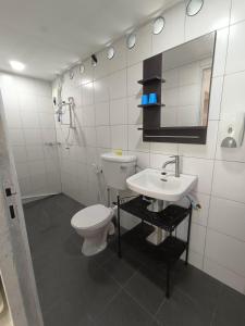 a white bathroom with a toilet and a sink at Tiongman Scubadive & Lodge in Tioman Island