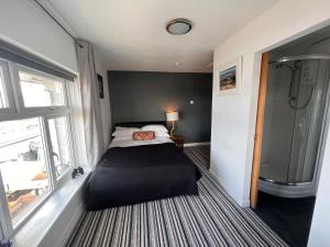 a bedroom with a large bed and a shower at Sids restaurant and bar with rooms in Cardiff