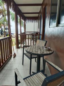 - une table et des chaises sur une terrasse couverte avec une table dans l'établissement Tiongman Scubadive & Lodge, à l'Île Tioman