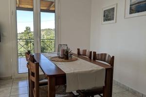 Un comedor con mesa y sillas y una ventana. en Haus Granes -Ferienwohnung am Meer für 2 Personen, en Finikounta 9 fotos más