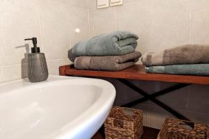 a bathroom with a white tub and towels on a shelf at Haus Granes -Ferienwohnung am Meer für 2 Personen in Finikounta