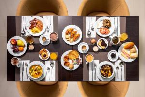 a table full of breakfast food on the backs of two people at Empire Marquês Hotel in Lisbon