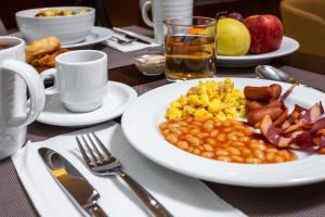 a table with a plate of breakfast food on it at Empire Marquês Hotel in Lisbon
