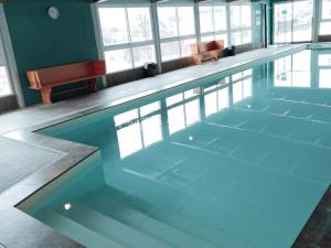 pusty basen w pokoju z oknami w obiekcie Studio avec piscine, WiFi et animaux admis à Jausiers - FR-1-165B-34 w mieście Jausiers