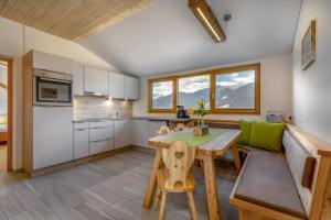 a kitchen and dining room with a table and chairs at Vernalhof Apt Panorama in Sluderno +9 photos