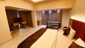 安巴拉Hotel Amar Palace的配有一张大床和一把椅子的酒店房间