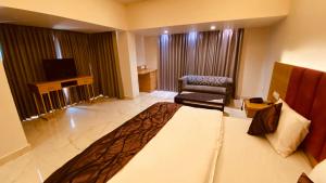Pokój hotelowy z łóżkiem i krzesłem w obiekcie Hotel Amar Palace w mieście Ambala