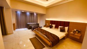 安巴拉Hotel Amar Palace的带一张大床和一把椅子的卧室