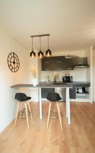 a kitchen with a table and two bar stools at LES DUNES Studio Cosy-Terrasse-Parking -Proche paris in Vitry-sur-Seine