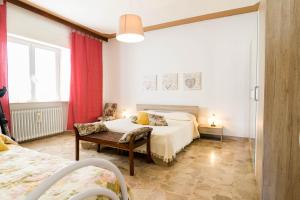 a bedroom with a bed and a chair in a room at Casa Berta, a due passi dal mare in Numana