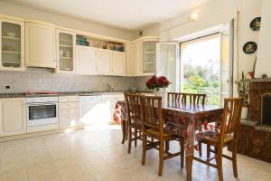 a kitchen with white cabinets and a table and chairs at Casa Berta, a due passi dal mare in Numana
