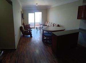 a living room with a table and chairs at L’amour Hotel apartment in Marsa Matruh