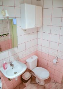 Baño de color rosa con aseo y lavamanos en Hostel Home, en Varsovia