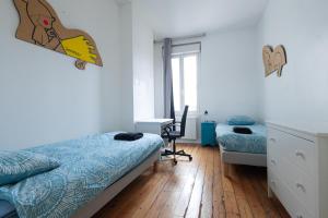 a bedroom with a bed and a desk and a desk at Maison spacieuse avec Jardin et Garage in Bordeaux