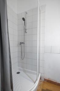 La salle de bains blanche est pourvue d'une douche et d'une baignoire. dans l'établissement Maison spacieuse avec Jardin et Garage, à Bordeaux