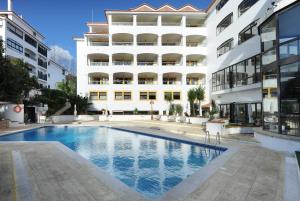 uma piscina em frente a um edifício em Clube do Lago Hotel em Estoril