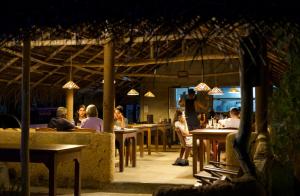 un grupo de personas sentadas en mesas en un restaurante en Wavelength, en Mirissa