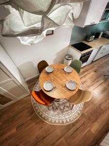 una mesa de madera en una habitación con sillas y una cocina en Au cœur de Castres, logement cosy classé 3*** en Castres