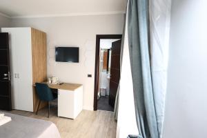 a room with a bed and a desk and a television at Seven Kings Relais in Rome