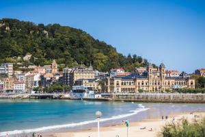 a view of a beach in front of a city at AMELIA suite apartment in San Sebastián