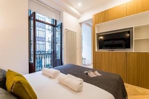 um quarto com uma cama e uma televisão na parede em CHURRUCA suite apartment em San Sebastián