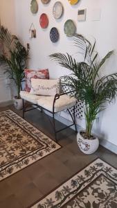 een woonkamer met een bank en planten en tapijten bij La Gitanilla Alojamiento & Encanto Jerez in Jerez de la Frontera