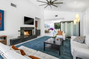 a living room with white furniture and a fireplace at Sundance Condo Permit# 2370 in Palm Springs