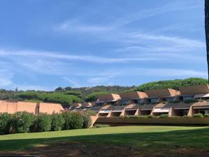 a row of houses with a green lawn at Appartamento 4 posti letto n 238 presso Residence Golf Hotel Punta Ala in Punta Ala