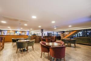 a restaurant with tables and chairs and a staircase at The Waterside Hotel and Leisure Club in Manchester