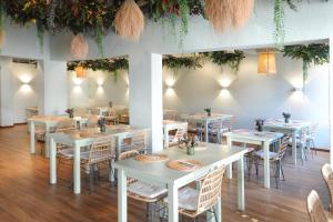 a dining room with white tables and chairs at Clube do Lago Hotel in Estoril