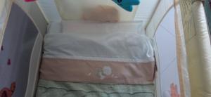 ein Babybett mit einem Bett in einem Zimmer in der Unterkunft La Buona Stella Apartment in Pistoia