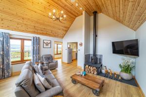 a living room with a couch and a fireplace at Roe Deer Lodge with Hot Tub in Cray