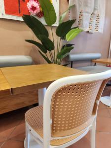 uma mesa de madeira com uma cadeira de vime e uma planta em Heeren Inn Melaka em Malaca