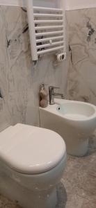 a bathroom with a white toilet and a sink at La Buona Stella Apartment in Pistoia