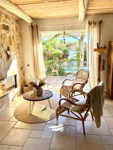 uma sala de estar com duas cadeiras e uma mesa em Magnifique villa de charme avec piscine em Draguignan