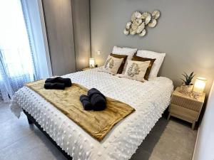 a bedroom with a white bed with two black hats on it at Ravissant T2 bord de mer garage privé classé 3 étoiles in Collioure