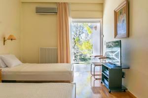 una camera d'albergo con due letti e una finestra di Eden Garden 3BR villa with Pool by JJ Hospitality a Oropos