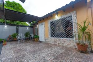 eine Terrasse mit Ziegelwand und eine Tür mit Tisch und Stühlen in der Unterkunft Doña Nelly in Asunción