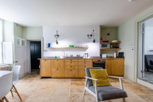 una cocina con armarios de madera y fregadero en Walcot Apartment, en Bath