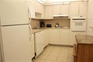 eine Küche mit weißen Schränken und einem weißen Kühlschrank in der Unterkunft Ocean Reserve 91 in Miami Beach