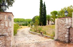 un ingresso a una casa in pietra con vialetto di Eden Garden 3BR villa with Pool by JJ Hospitality a Oropos