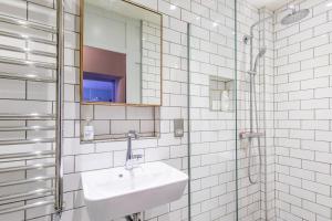 a white bathroom with a sink and a mirror at Walcot Apartment in Bath +11 photos