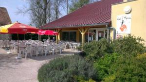 un grupo de mesas y sillas fuera de un restaurante en LOGIS - Hôtel & Restaurant le Grand Terre, en Chartronges
