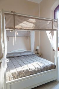 Una cama blanca con dosel en un dormitorio en Leone X Guest House, en Florencia