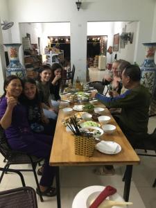 Văn Lâm的住宿－Tam Coc Scenery Homestay，一群坐在桌子旁吃食物的人