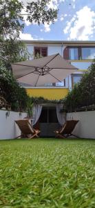 eine Terrasse mit zwei Stühlen und einem Sonnenschirm in einem Hof in der Unterkunft Holiday Home Casa Vacanza Il Gelsomino IUNQ9330 in Siniscola
