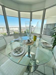 - une table en verre dans une chambre avec vue sur la ville dans l'établissement L'Océane - Magnifique vue mer, à La Rochelle